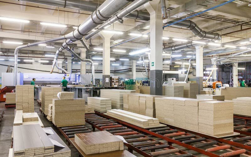 Panel production line with stacked boards moving along roller conveyors