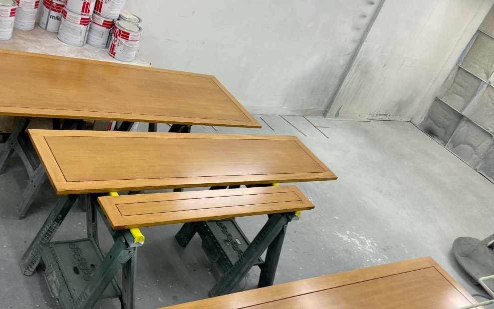 Finished cabinet panels on sawhorses in a woodworking factory
