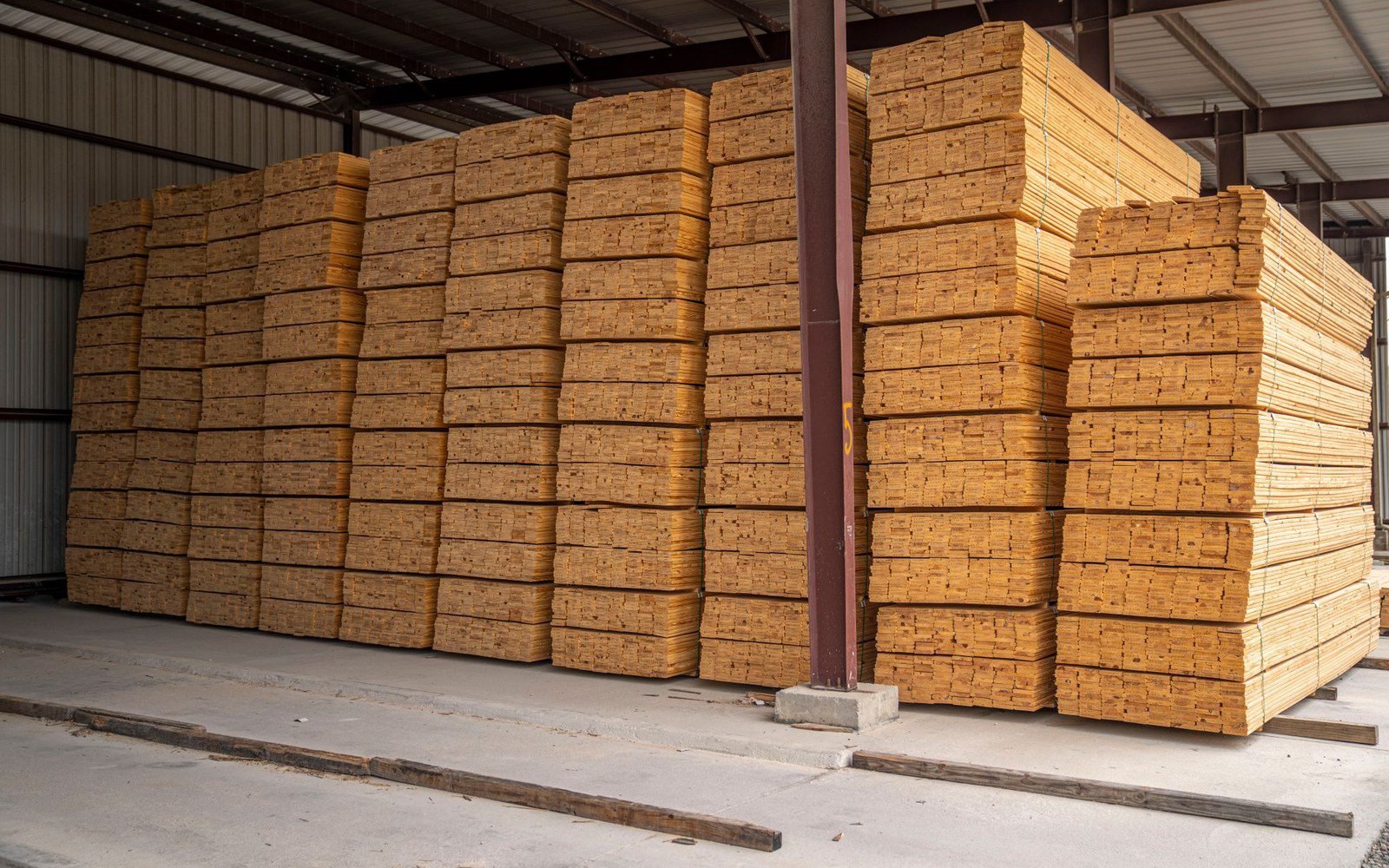 Neatly stacked boards in a warehouse, kiln-dried in chamber loads