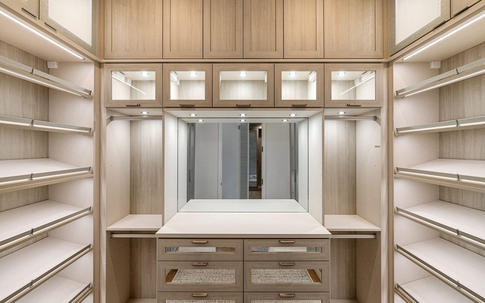 Oak walk-in closet dressing area with drawer bank and mirror