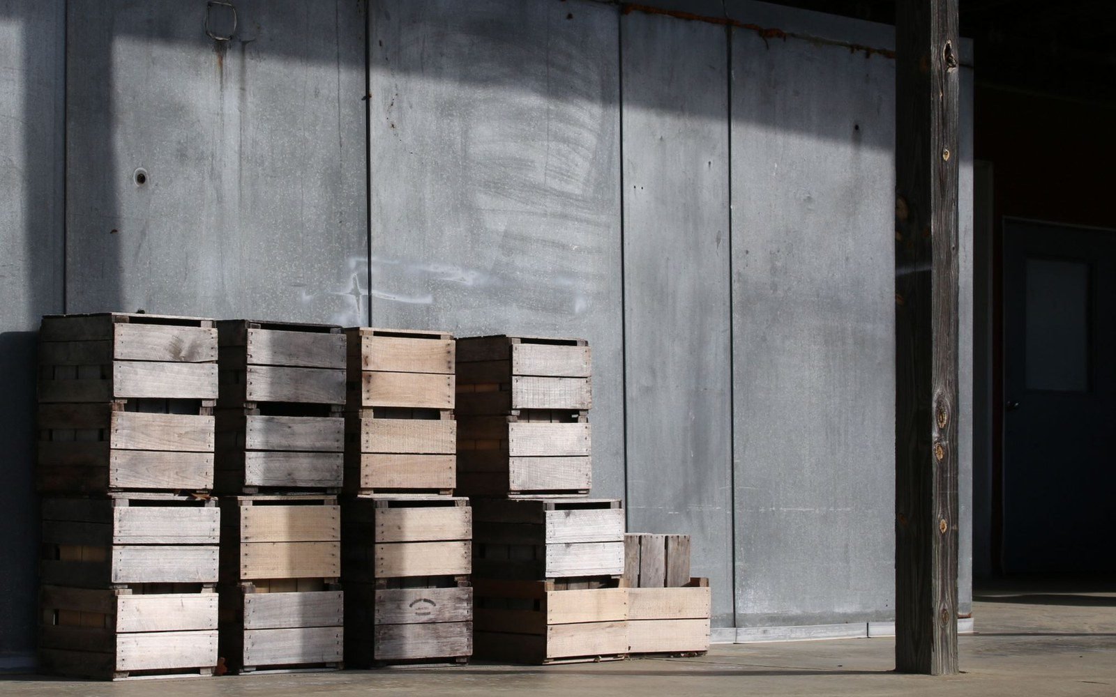 Stacks of export wooden crates against a plywood wall