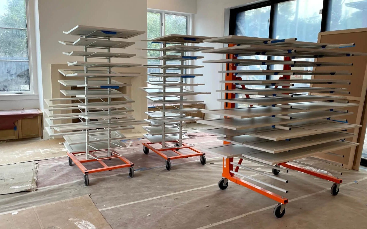 Cabinet doors on mobile drying racks after finishing in the paint shop