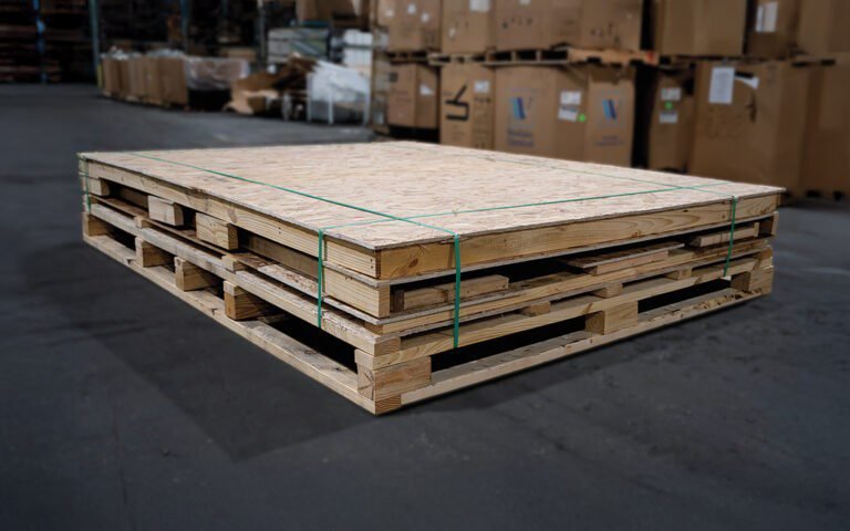 Strapped pallets staged in the warehouse beside boxed parts, ready for container loading