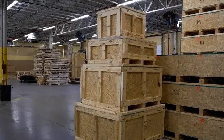 Flat-packed crates on pallets staged in the warehouse before the container loads