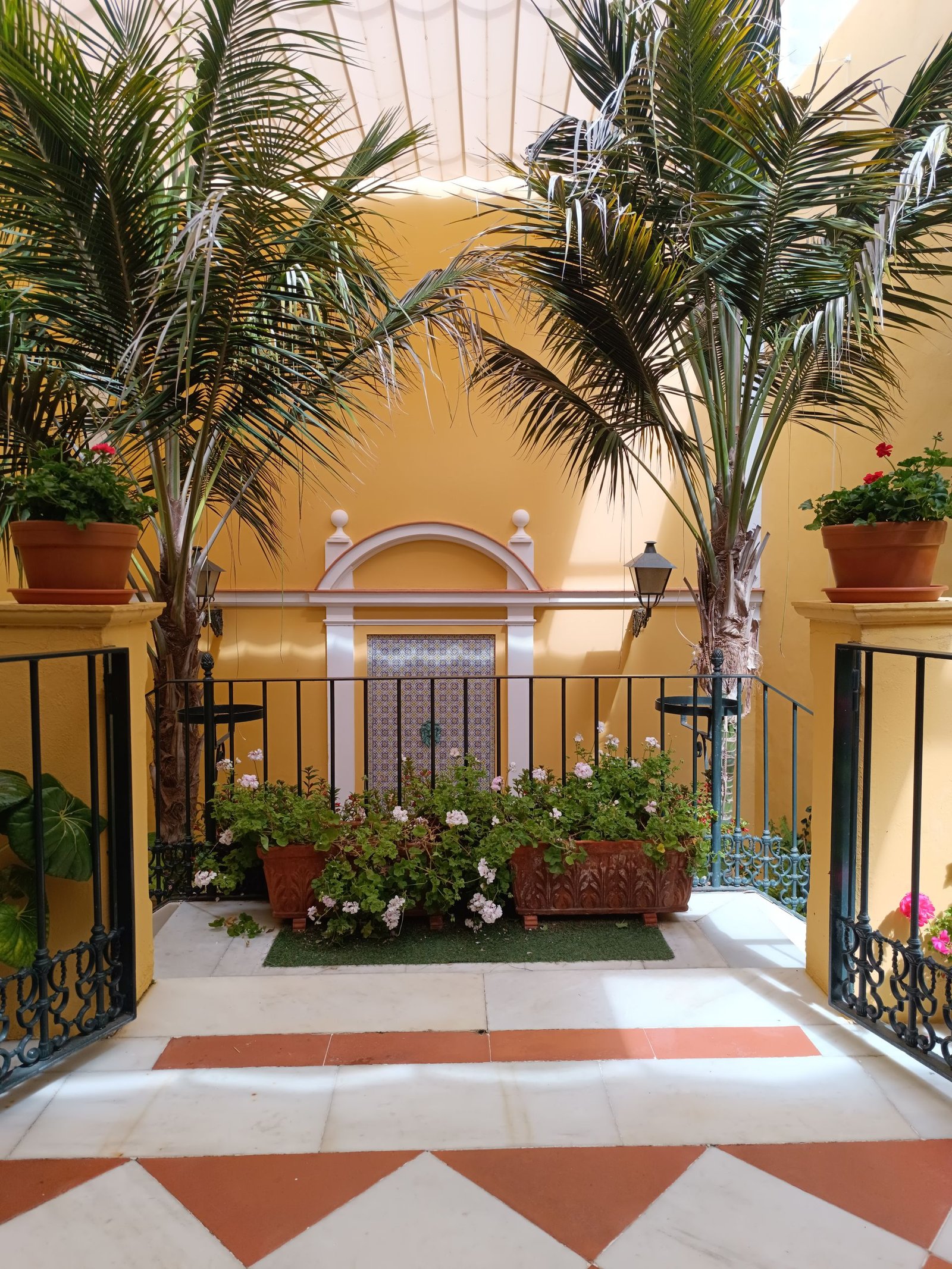 terracotta and white patterned tile courtyard with palm trees