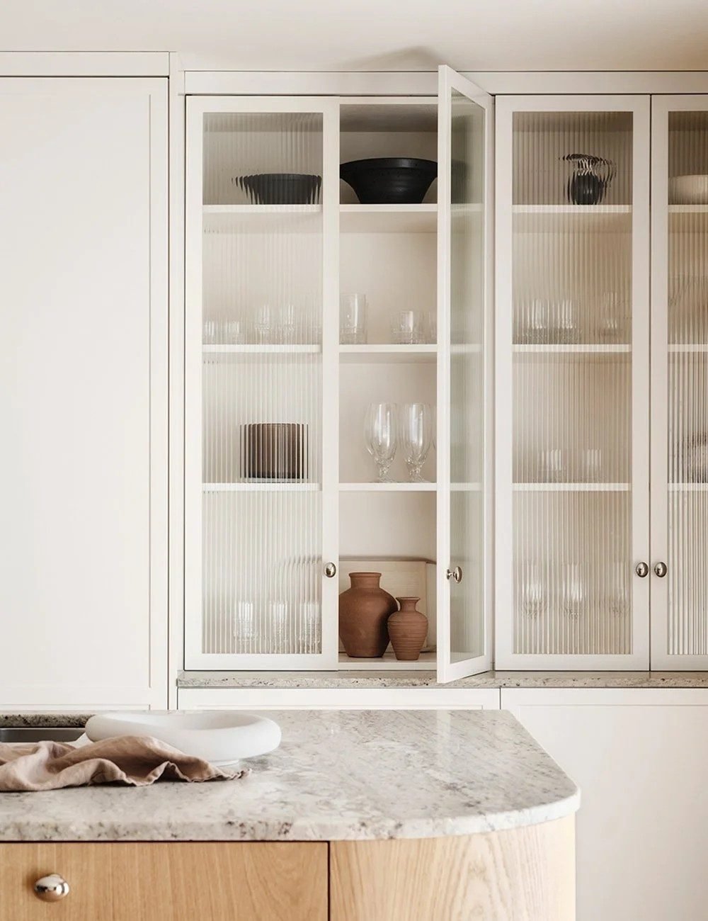 White fluted glass display cabinet with glassware