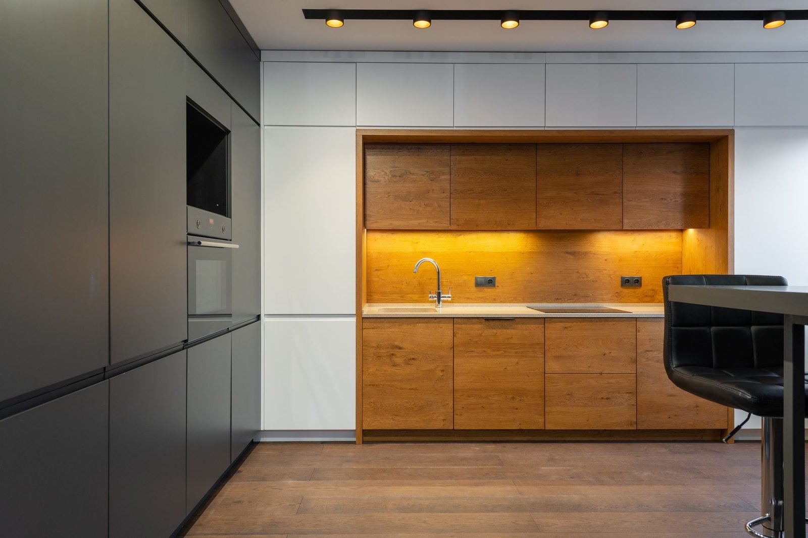 Handleless kitchen in grey and white with a back-lit oak niche
