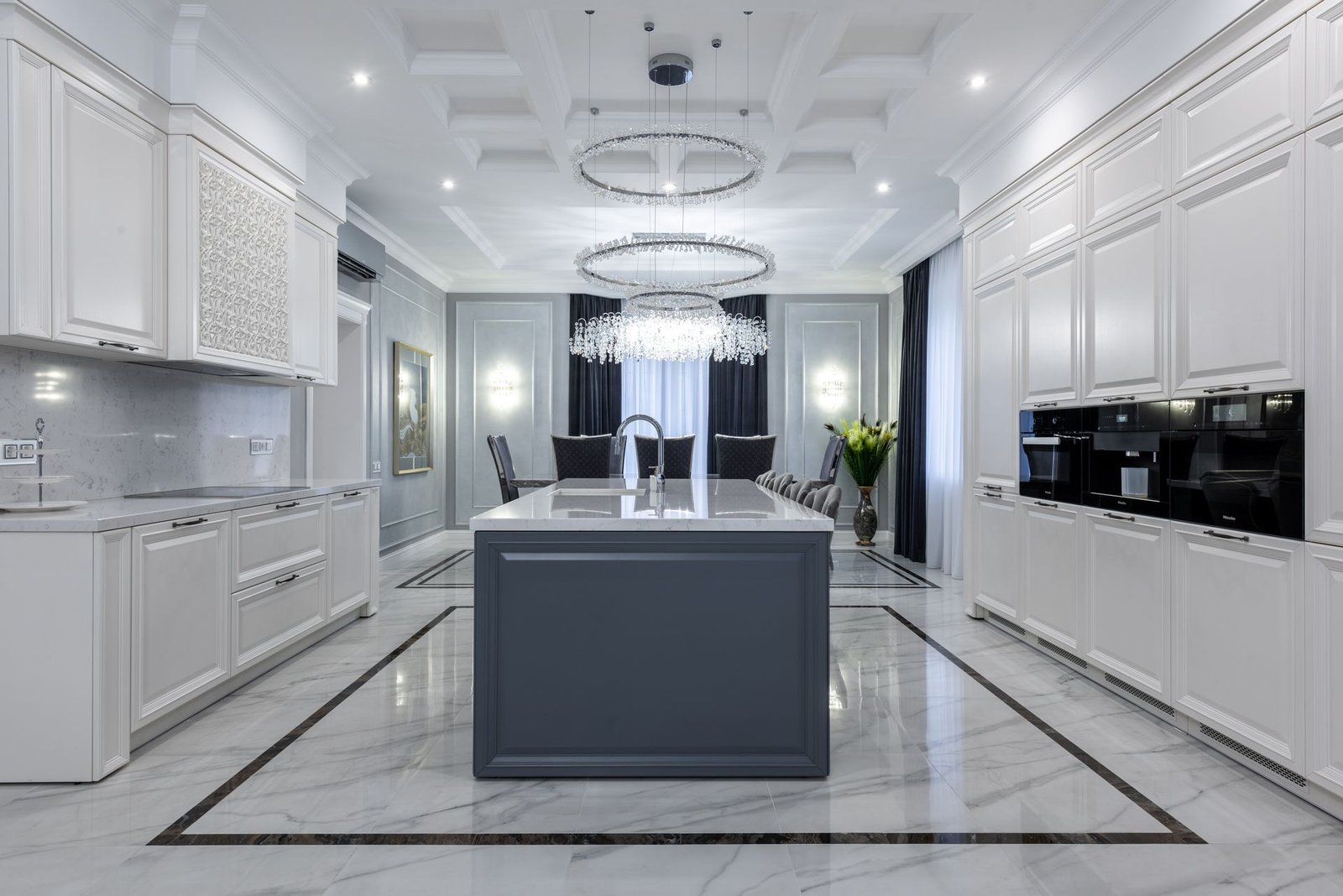 full-height island run in a villa kitchen with matching tall units