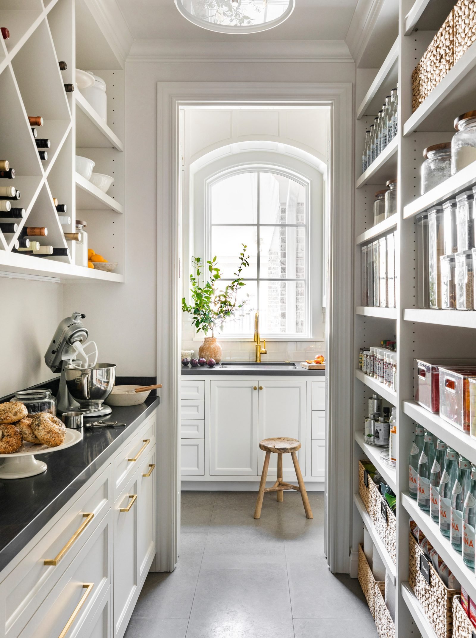 White walk-in pantry with full-height shelving and worktop