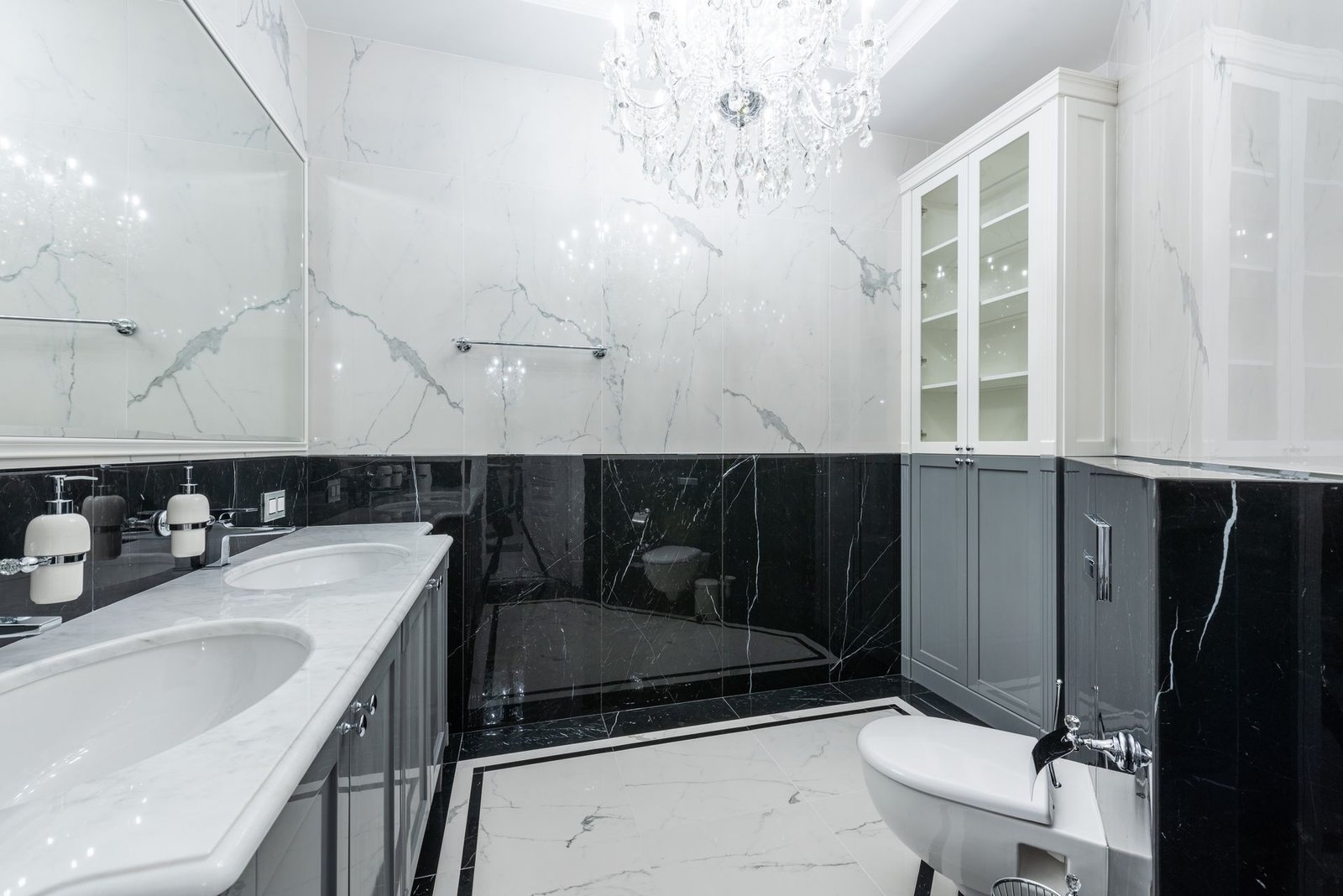 White marble bathroom with chandelier and grey vanity