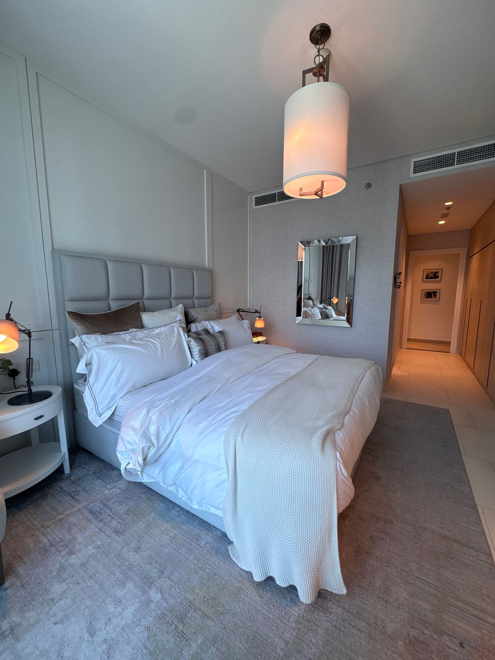 Hotel-style white bed in a calm grey room
