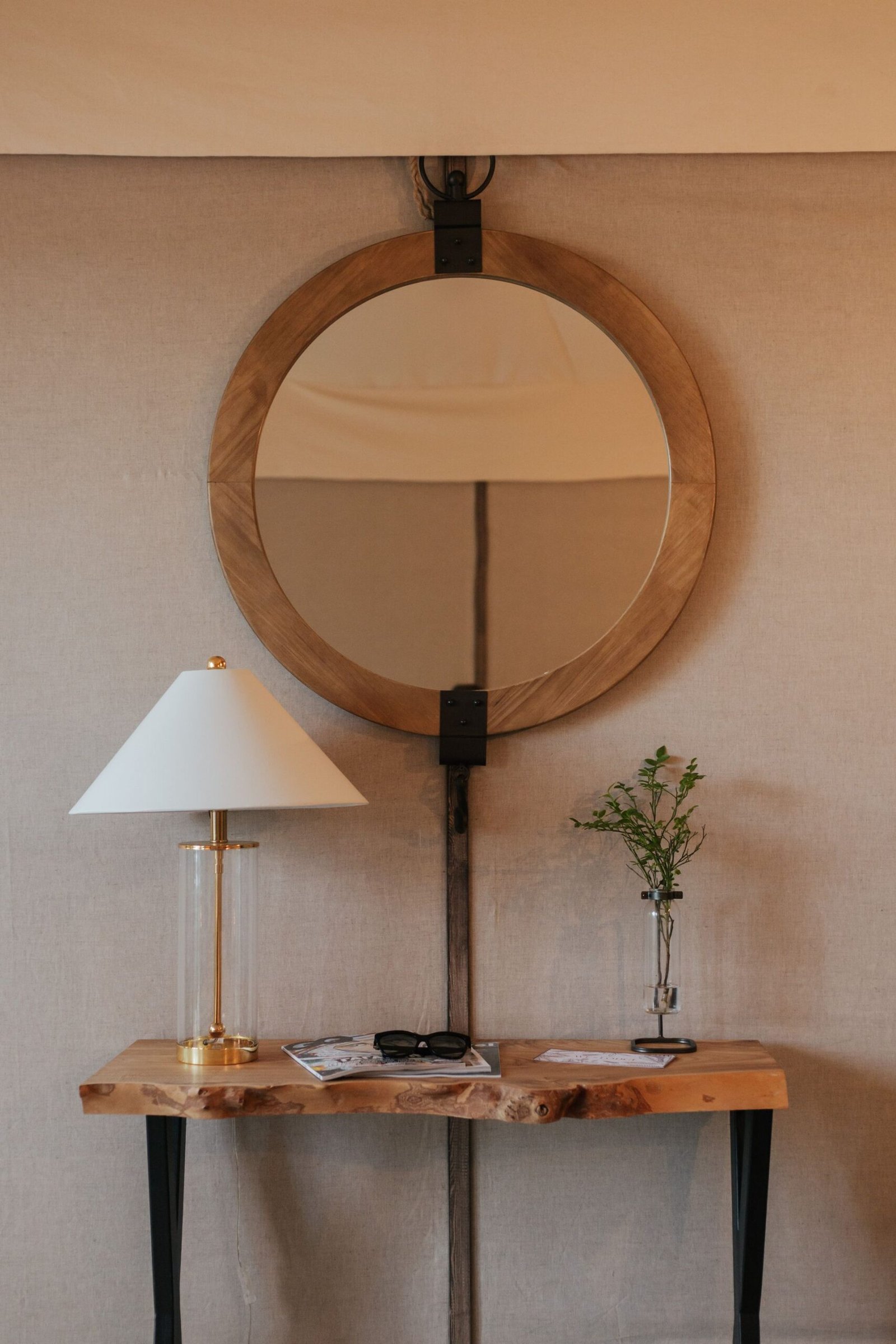 Round wood-framed mirror over a timber console