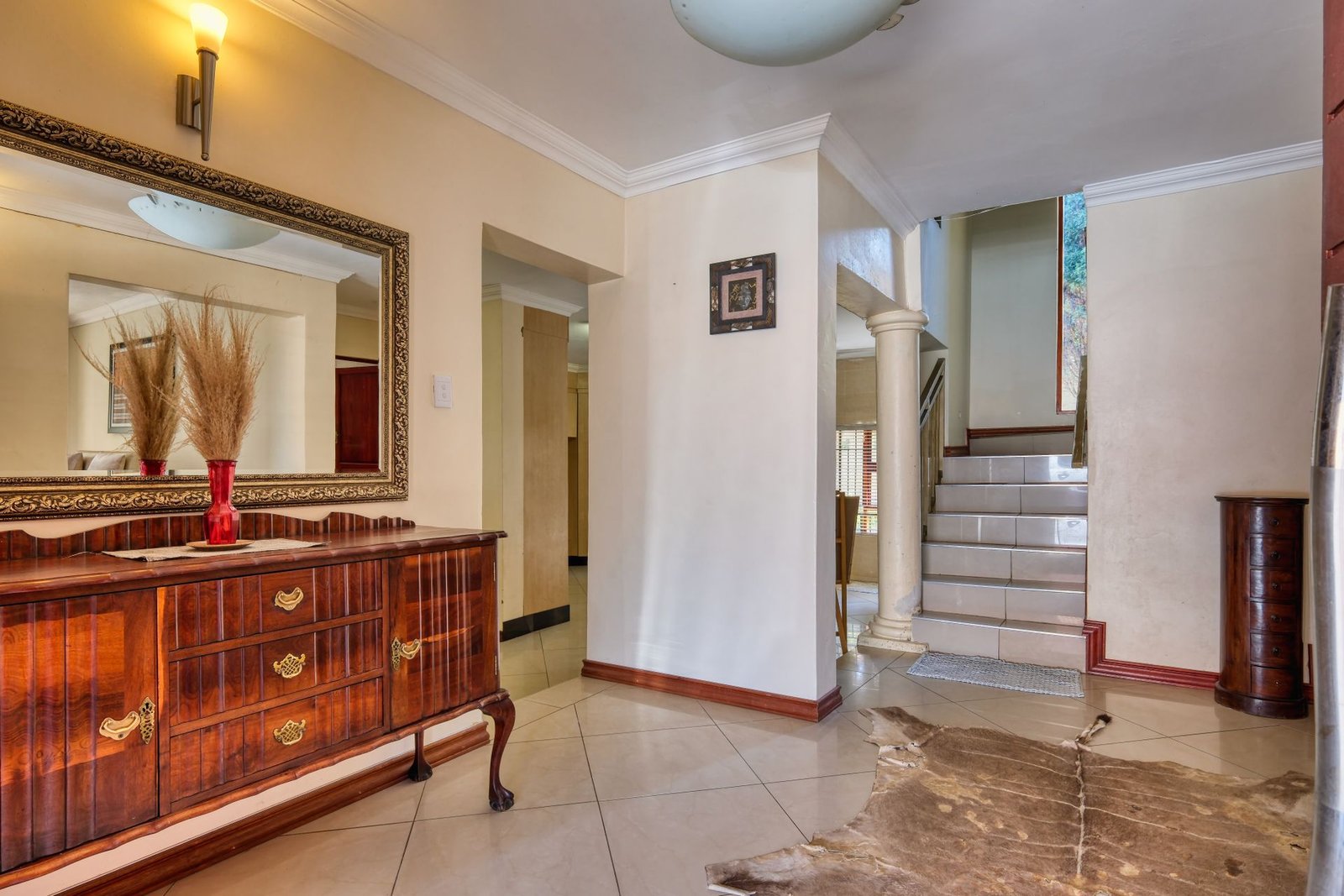 Statement mirror and wooden dresser in a foyer
