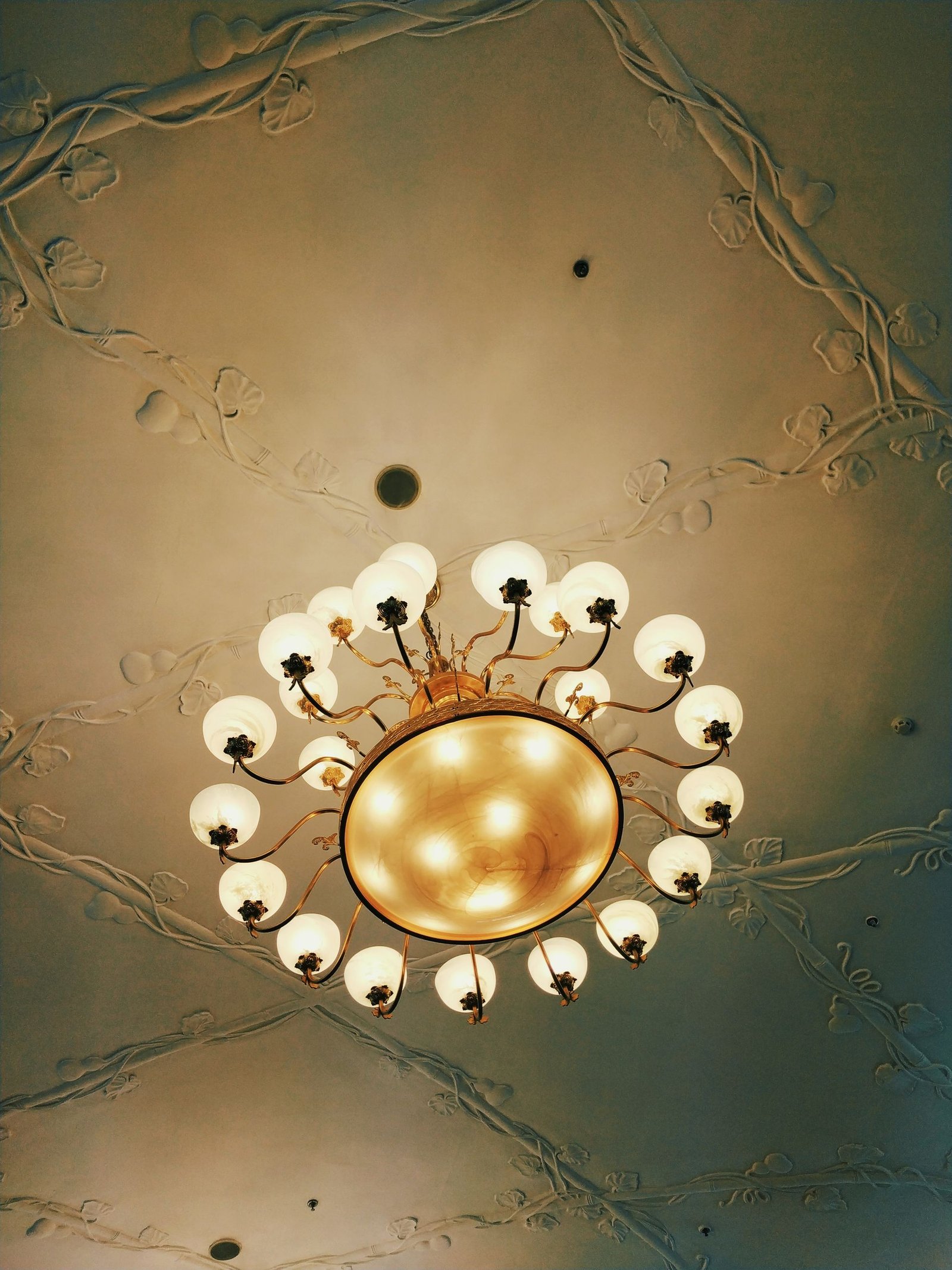 Brass ring ceiling light with globe bulbs on a beige ceiling