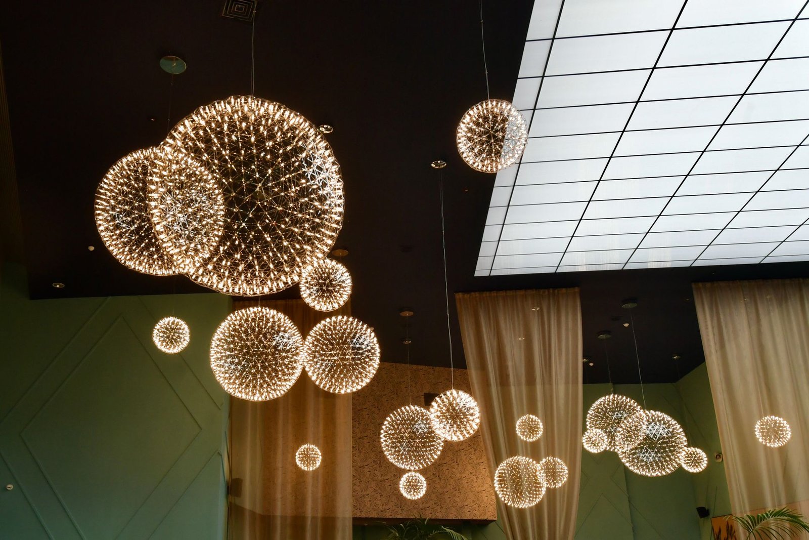 Crystal orb pendant cluster beside a glass roof