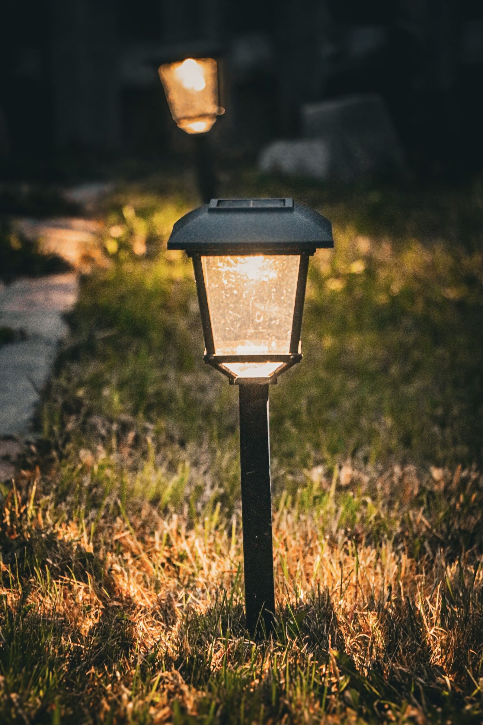 Solar garden lantern on a grass path at dusk