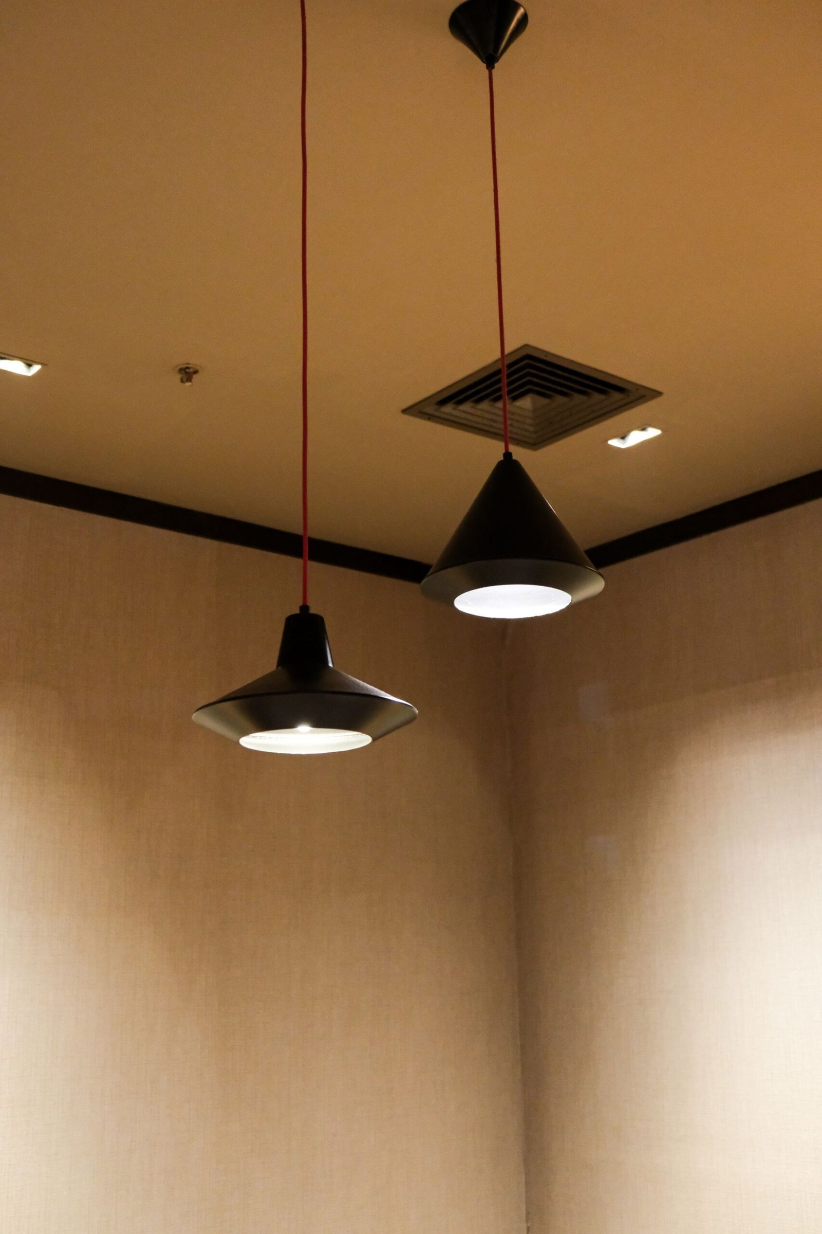 Cluster of black cone pendant lights in a timber-lined room