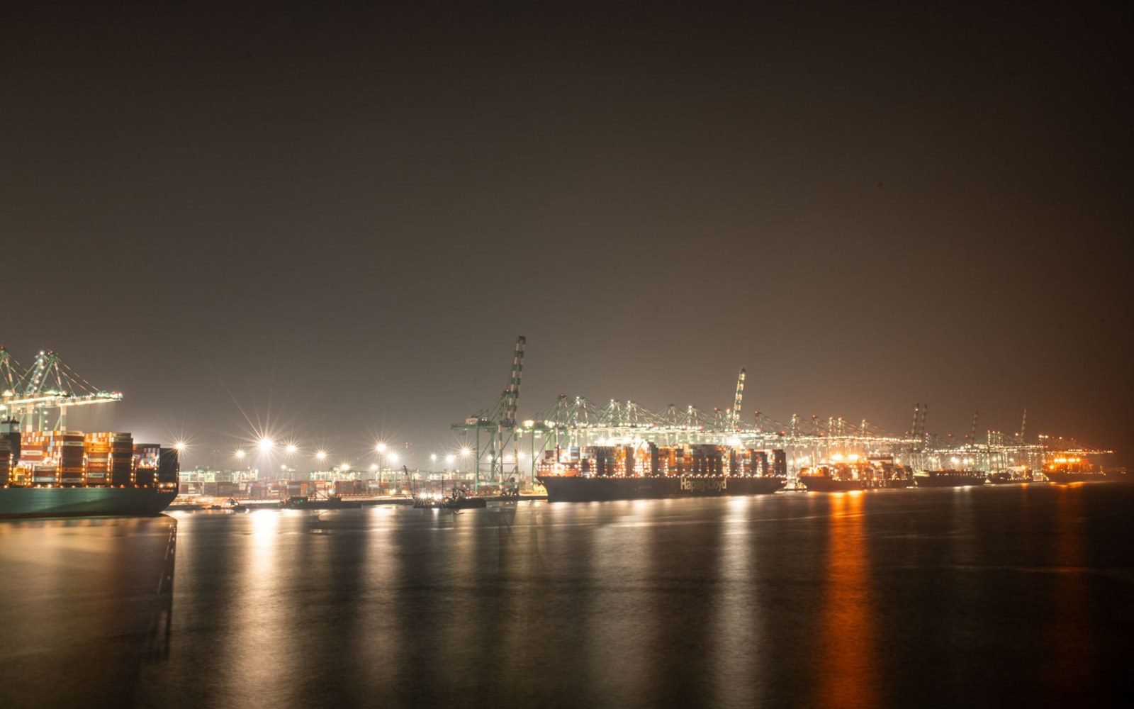 Illuminated port at night with vessels in the water, the ocean leg of the lane (stock photo, Pexels 39621567)