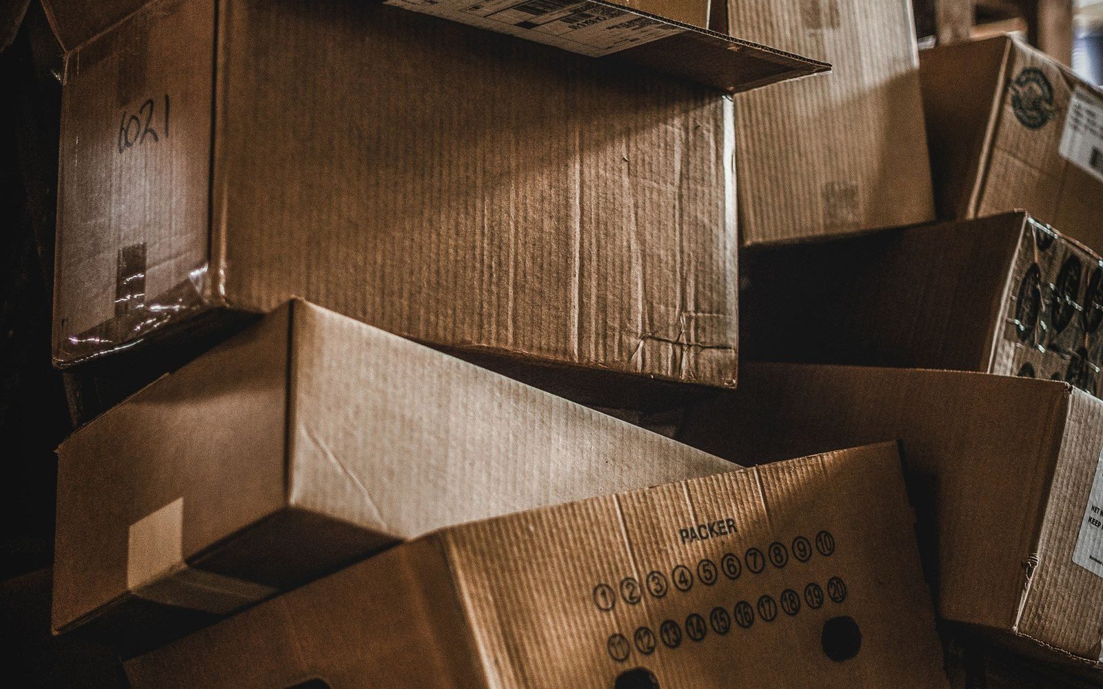 Stacked wooden export crates with handwritten carton numbers and packer marks awaiting loading