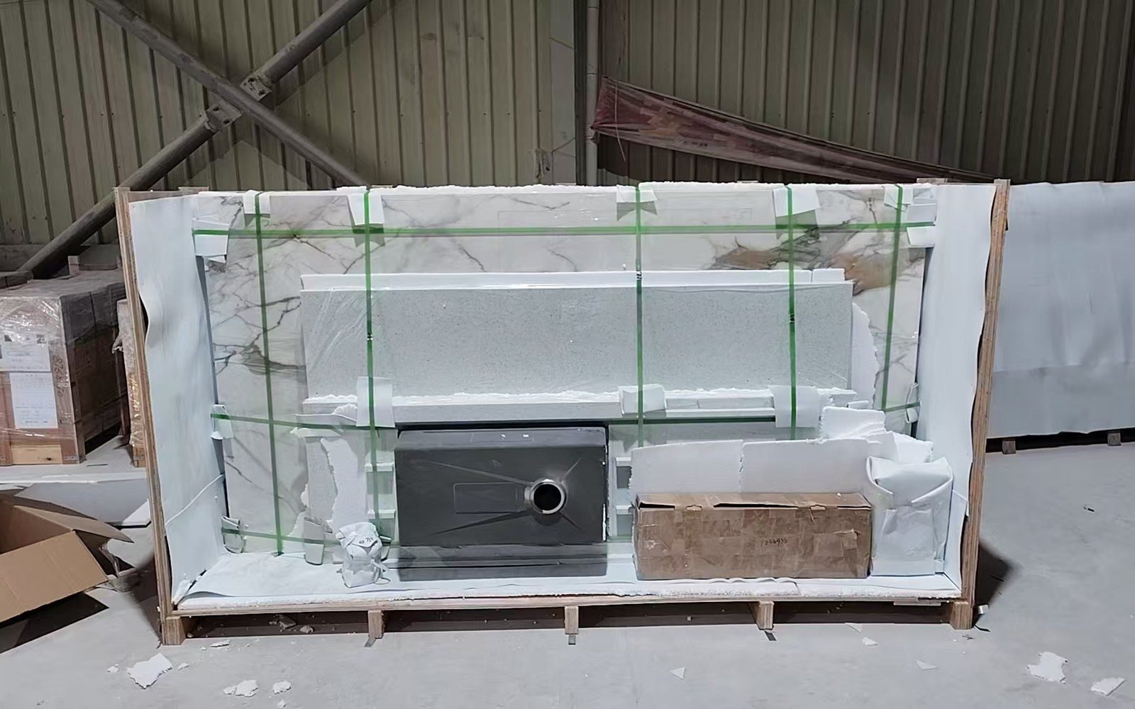 Stone worktops strapped inside a timber-framed crate with a sink cutout, ready for container loading