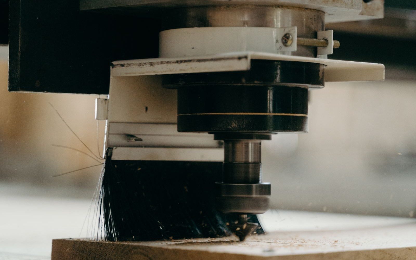 Close-up of a CNC spindle cutting a board in a wood shop