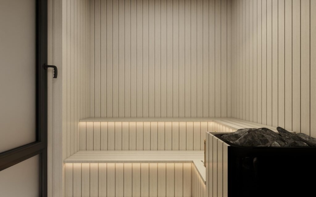 Light wood villa sauna room with two-tier backlit bench, stone heater and frosted glass door